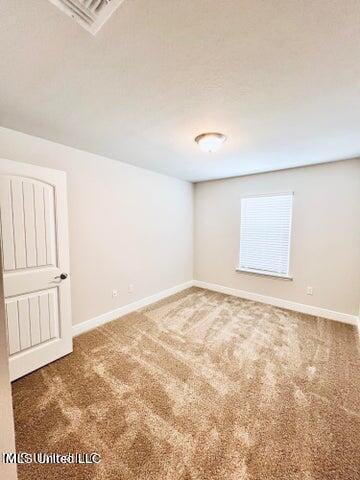 empty room with dark colored carpet