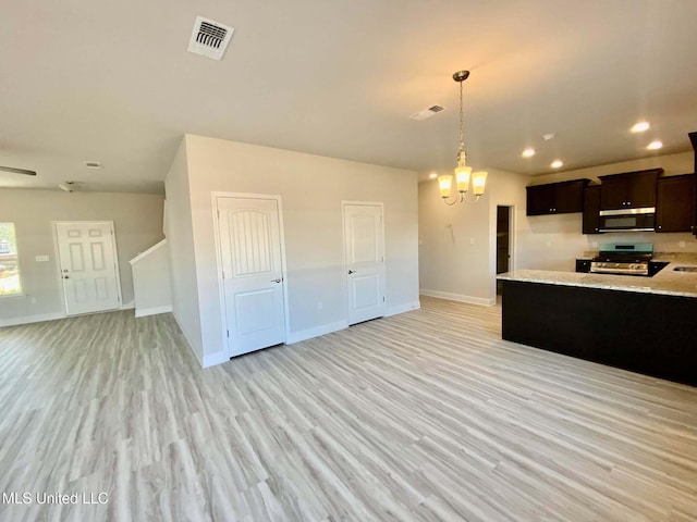 kitchen with stainless steel appliances, a notable chandelier, pendant lighting, light hardwood / wood-style flooring, and sink