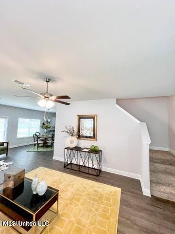 living room featuring ceiling fan and dark hardwood / wood-style flooring