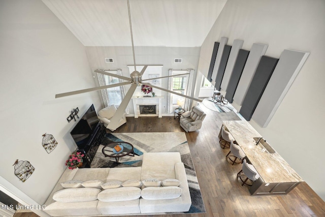 living room featuring ceiling fan, hardwood / wood-style flooring, and high vaulted ceiling