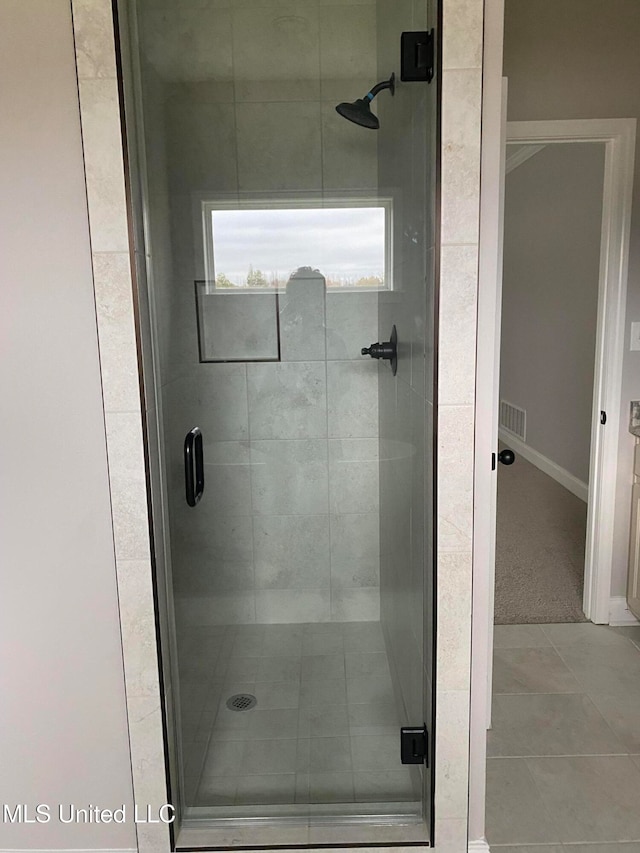 bathroom with tile patterned floors and walk in shower