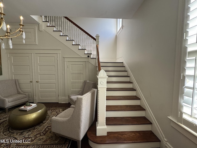 stairway with a chandelier and wood finished floors