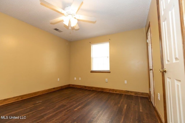 empty room featuring ceiling fan, a textured ceiling, and dark hardwood / wood-style flooring