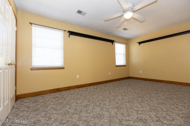 empty room featuring ceiling fan, a textured ceiling, and carpet floors