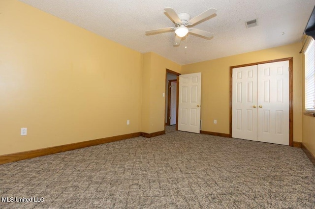 unfurnished bedroom with a closet, a textured ceiling, carpet flooring, and ceiling fan