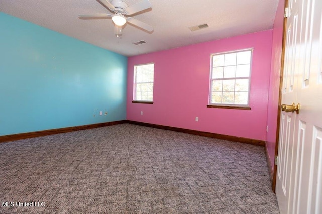 carpeted spare room with a textured ceiling and ceiling fan