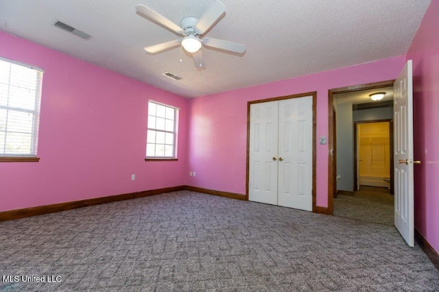 unfurnished bedroom featuring a textured ceiling, carpet floors, and ceiling fan