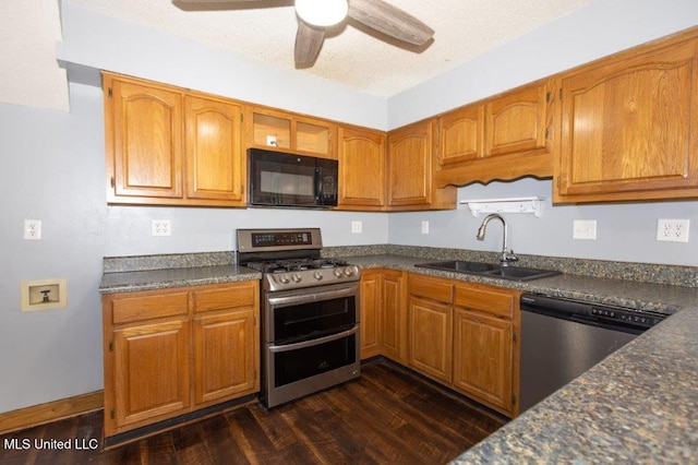 kitchen featuring sink, a textured ceiling, ceiling fan, stainless steel appliances, and dark wood-type flooring