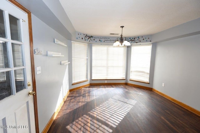 unfurnished dining area with a chandelier and dark hardwood / wood-style flooring