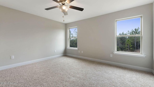 empty room featuring carpet flooring, a ceiling fan, and baseboards