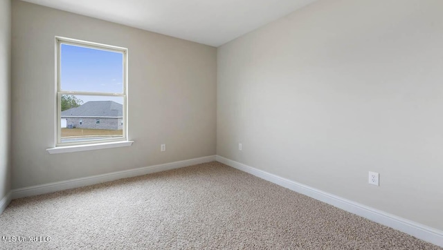 unfurnished room with carpet floors and baseboards