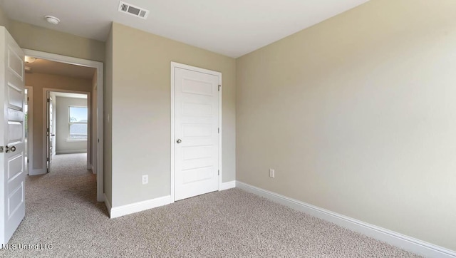 unfurnished bedroom with light carpet, baseboards, and visible vents