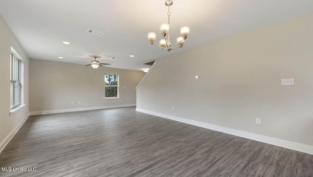 unfurnished room with visible vents, baseboards, dark wood-style flooring, and ceiling fan with notable chandelier