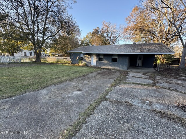 ranch-style home featuring a carport and a front lawn