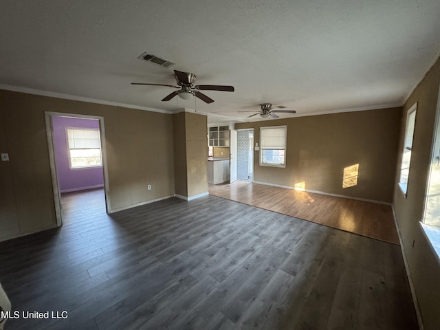 unfurnished living room with a textured ceiling, crown molding, ceiling fan, and dark wood-type flooring