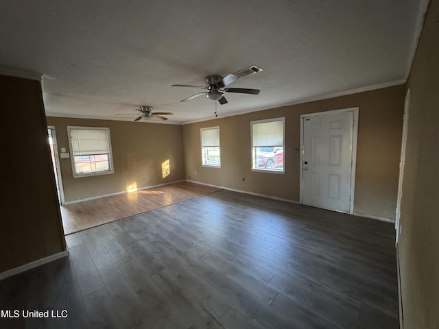 empty room with ceiling fan, crown molding, and dark wood-type flooring