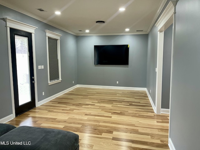 foyer entrance featuring ornamental molding, a wealth of natural light, and light wood-type flooring