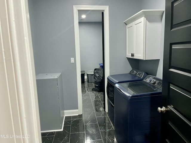 washroom featuring washer and clothes dryer and cabinets