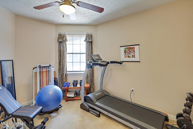 exercise room with baseboards, a textured ceiling, carpet, and a ceiling fan