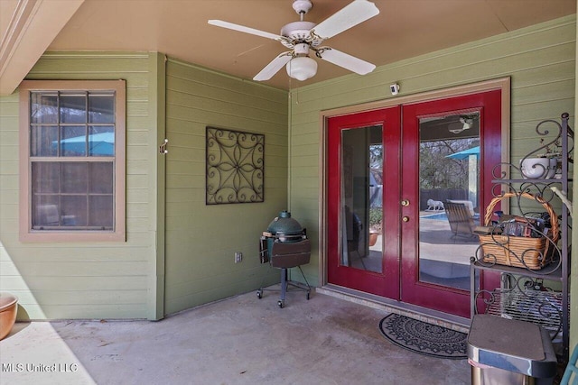 entrance to property with concrete block siding, french doors, and ceiling fan