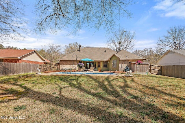 rear view of house featuring a patio, a lawn, a fenced in pool, and a fenced backyard