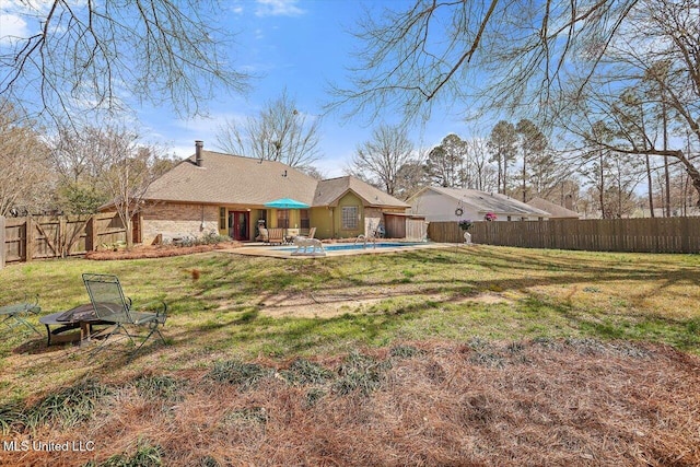 rear view of property with a patio area, a yard, a fenced in pool, and a fenced backyard