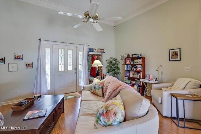 living room with light wood-type flooring, a ceiling fan, and crown molding