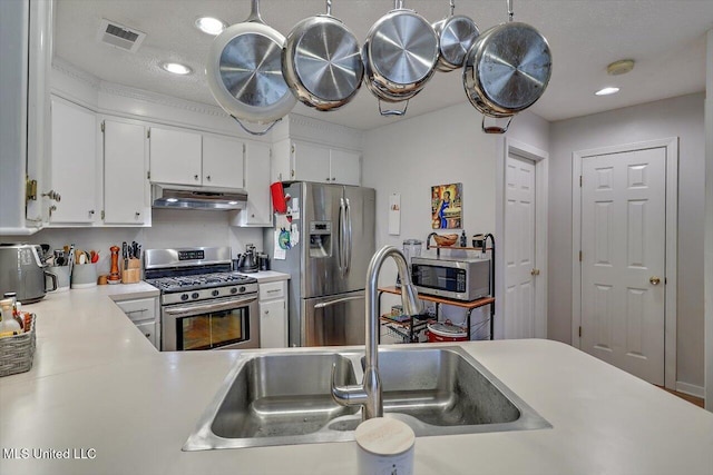 kitchen featuring visible vents, under cabinet range hood, a sink, appliances with stainless steel finishes, and light countertops