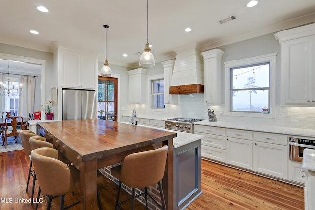 233 Arbor Trl, Brandon, MS 39047 - kitchen featuring recessed lighting, custom range hood, appliances with stainless steel finishes, white cabinets, and visible vents
