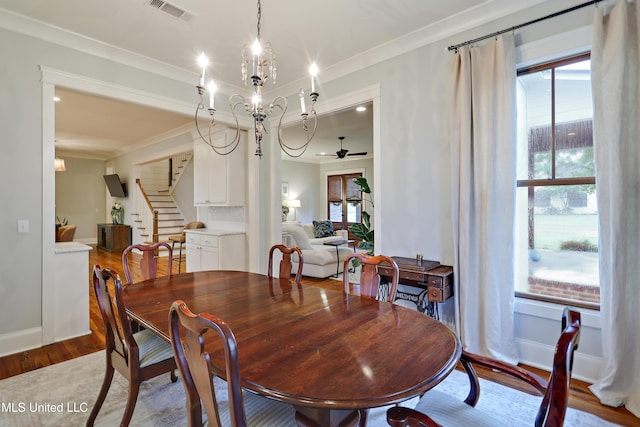 233 Arbor Trl, Brandon, MS 39047 - dining room featuring light wood-style flooring, stairway, visible vents, ornamental molding, and ceiling fan with notable chandelier