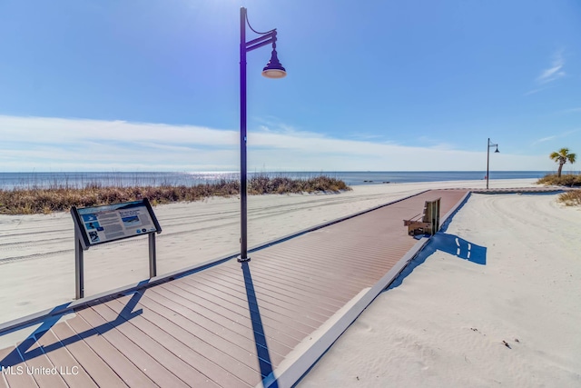 view of property's community featuring a water view and a beach view