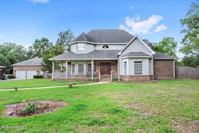 view of front of property with a porch, a garage, and a front lawn