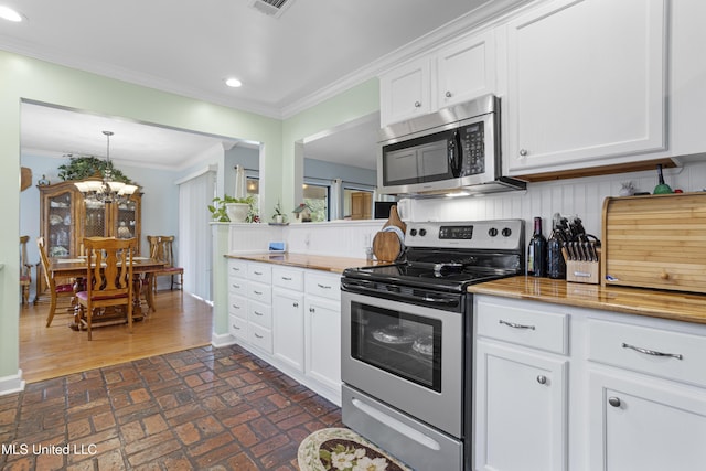 kitchen featuring tasteful backsplash, white cabinets, stainless steel appliances, and ornamental molding