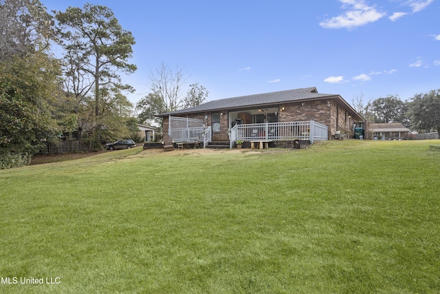 back of property with a lawn and a deck