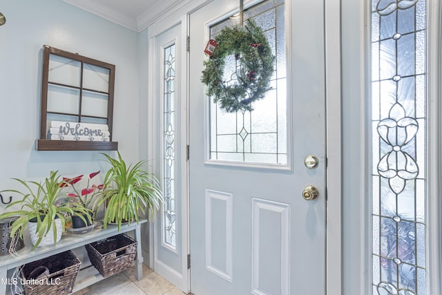 foyer with crown molding and light tile patterned flooring