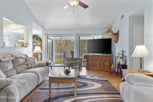 living room with ceiling fan, wood-type flooring, and lofted ceiling