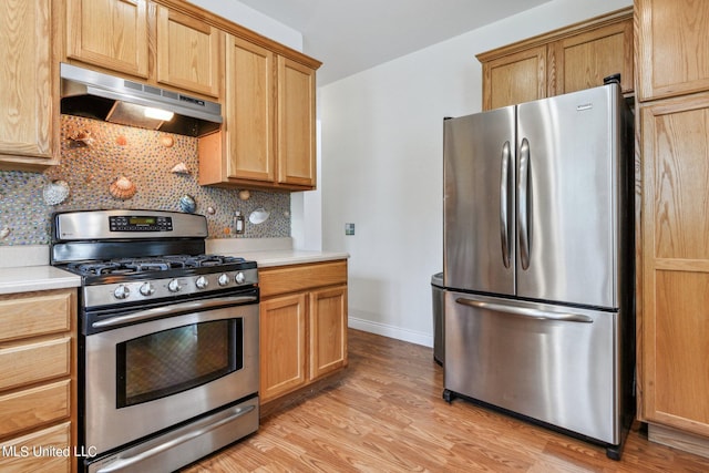 kitchen with stainless steel appliances, tasteful backsplash, and light hardwood / wood-style flooring