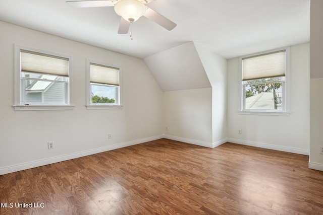 additional living space featuring hardwood / wood-style flooring, vaulted ceiling, and ceiling fan