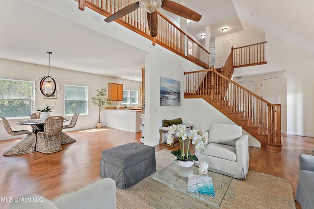 living room with light wood-type flooring, a high ceiling, and a wealth of natural light