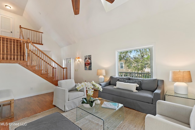 living room featuring a high ceiling, wood-type flooring, and ceiling fan