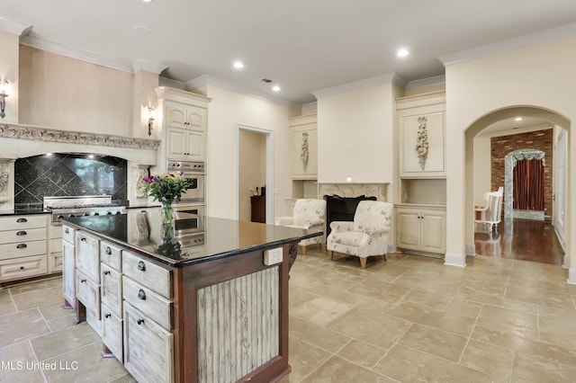 130 Bridgewater Xing, Ridgeland, MS 39157 - kitchen featuring dark countertops, tasteful backsplash, ornamental molding, stainless steel double oven, and arched walkways