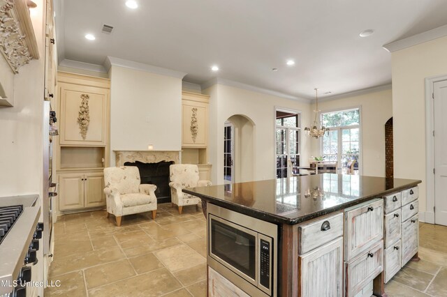 130 Bridgewater Xing, Ridgeland, MS 39157 - kitchen with stainless steel microwave, arched walkways, cream cabinets, crown molding, and a chandelier