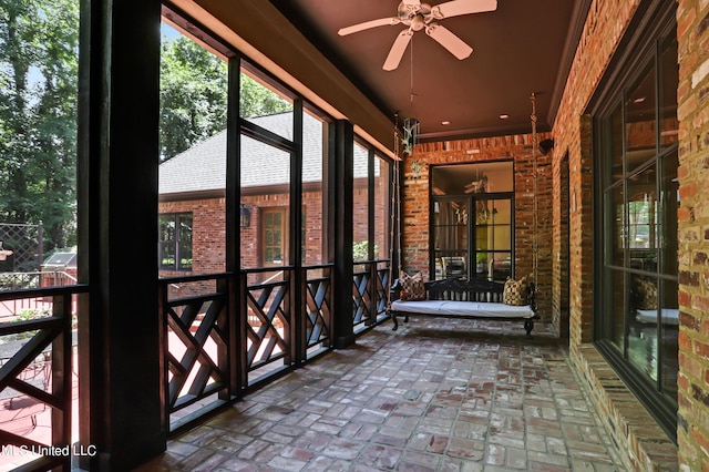 unfurnished sunroom featuring ceiling fan