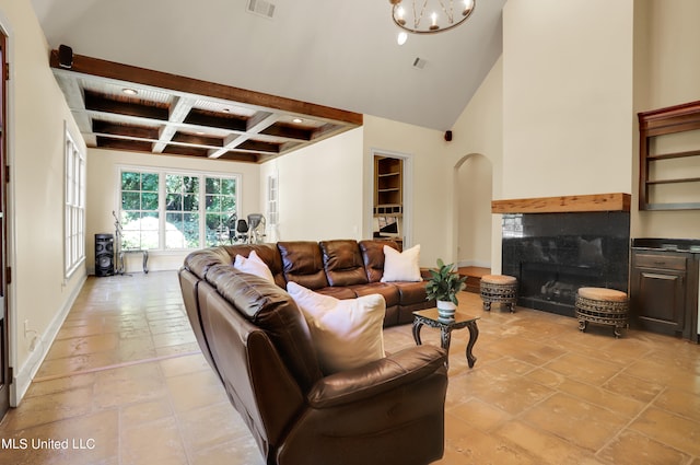 living room featuring coffered ceiling, a high ceiling, beamed ceiling, a chandelier, and a fireplace