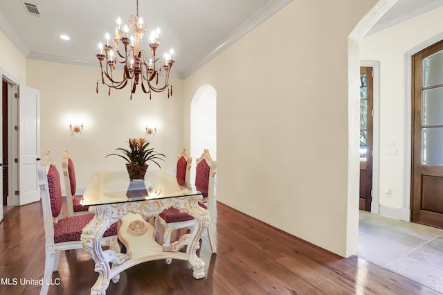 130 Bridgewater Xing, Ridgeland, MS 39157 - dining space with arched walkways, a chandelier, wood finished floors, and ornamental molding