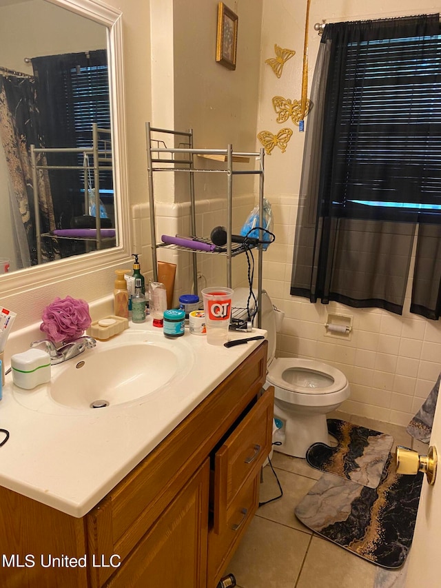 bathroom featuring tile walls, vanity, toilet, and tile patterned flooring