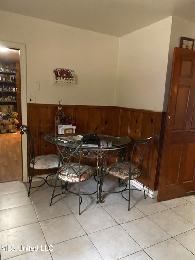 tiled dining space with wood walls