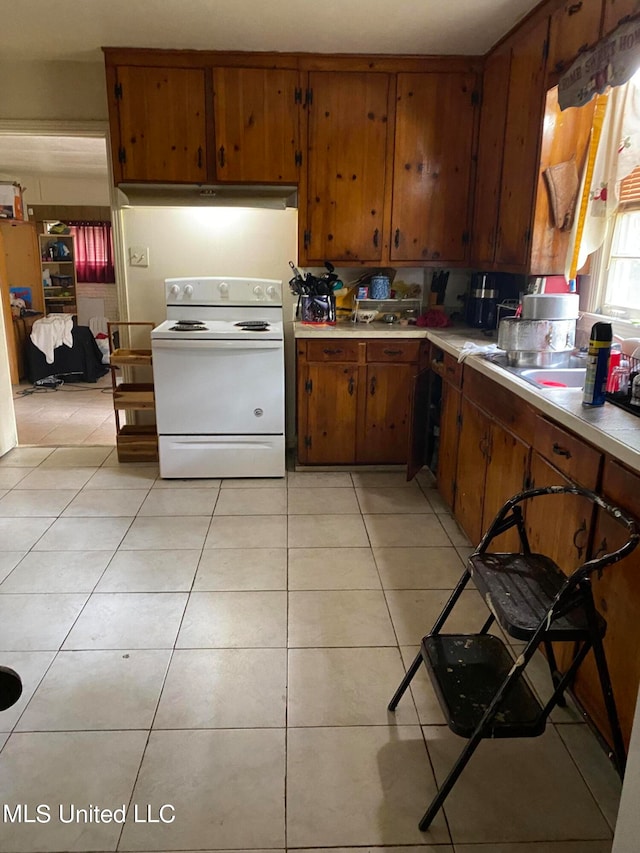 kitchen with light tile patterned floors and white range with electric cooktop