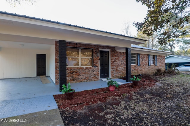 816 NE Boling St, Magee, MS 39111 - property entrance with brick siding, an attached carport, and a porch