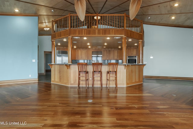 141 Janelle Dr, Bay Saint Louis, MS 39520 - kitchen featuring stainless steel appliances, dark wood-style flooring, a kitchen bar, stone counters, and wood ceiling